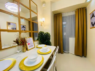 a dining room table with yellow and white dishes on it at Condotel at S Residences near SM MOA, SMX, Arena, NAIA Airport in Manila