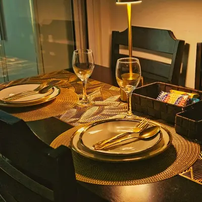 a table with plates and silverware and wine glasses at Azure Urban Resort Residences by Moldez Staycation in Manila