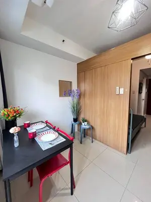 a living room with a black table and red chairs at Unistay SHELL Residences Amazing Pool view near MOA in Manila