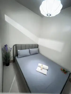 a bed in a room with a light at Unistay SHORE 3 Pool view w Balcony near MOA in Manila
