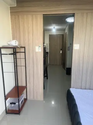 a room with a bed and a hallway with at Shore 2 Residences Executive Suite by JMS in Manila