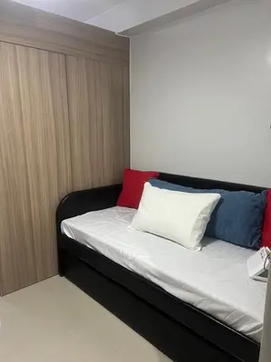 a bed with two pillows on it in a room at Shore 2 Residences Executive Suite by JMS in Manila