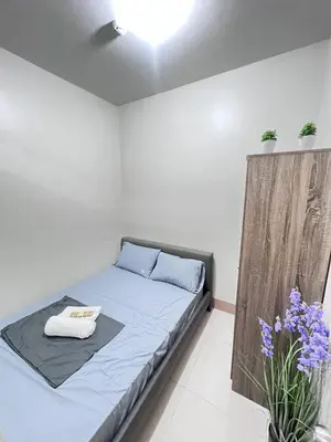 a bedroom with a bed with blue sheets and purple flowers at Unistay SHORE 3 Poolview w Balcony in Manila