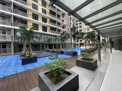 a building with a pool with potted trees in a courtyard at 1BR Executive Suite Beside Okada & Solaire - 4pax in Manila