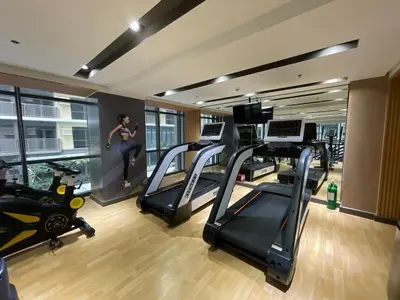 a gym with tread machines and a woman on a treadmill at Spacious 1BR near Airport across Okada, Solaire in Manila