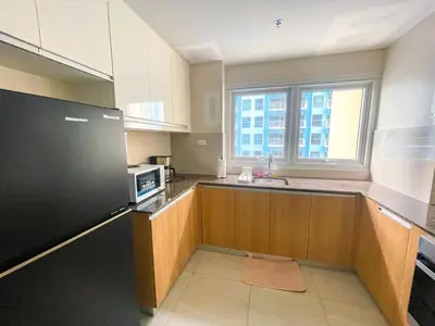 a large kitchen with a sink and a microwave at Spacious 2BR Luxury Suite across Okada, Airport in Manila