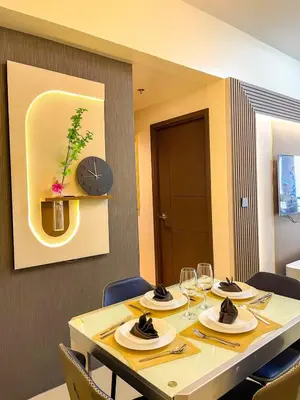 a dining room table with chairs and a clock on the wall at Spacious 2BR Luxury Suite across Okada, Airport in Manila