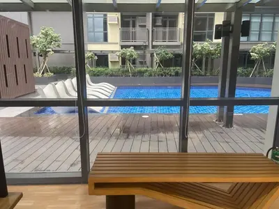 a view of a pool through a window with a bench at Spacious 2BR Luxury Suite across Okada, Airport in Manila