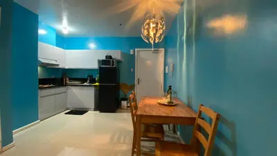 a kitchen with a table and a blue wall at The Radiance Manila in Manila