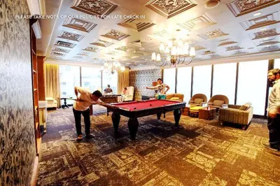 a man playing a game of pool table in a room at David Gelber in Manila