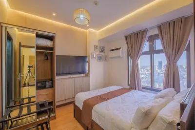 a bedroom with a bed and a large window at EC Suites Modern 1Br Suite w Balcony in Pasay in Manila