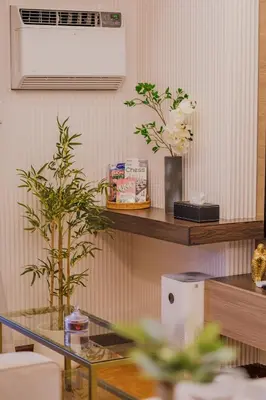 a living room with a glass table with two plants at EC Suites Modern 1Br Suite w Balcony in Pasay in Manila