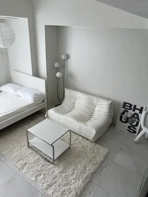 a white living room with a couch and a coffee table at Cloud Space Studio near Eastwood in Manila