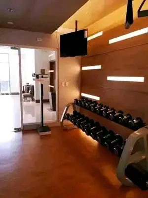 a gym with a bunch of dumbbells on a wall at Romeotwopalmtreevilla in Manila