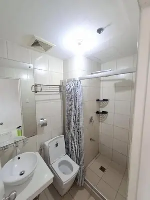 a bathroom with a toilet and a sink and a shower at Modern Studio Birch Tower Near Malls & Nightlife in Manila
