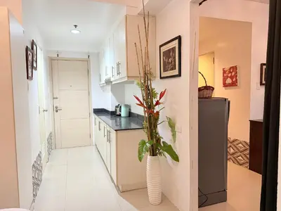 a kitchen with a vase with a plant in it at The Nook Stays at Sea Residences in Manila