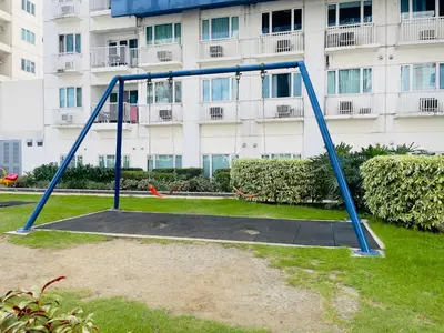 a blue swing set in front of a building at The Nook Stays at Sea Residences in Manila
