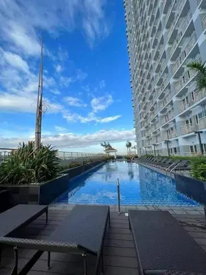 a large building with a swimming pool next to a building at CozyStay by MA-Coast Residences in Manila
