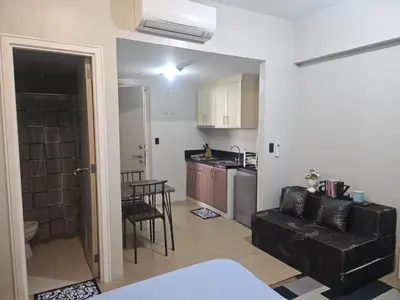 a kitchen and a living room with a couch and a table at Jace Oasis in Manila