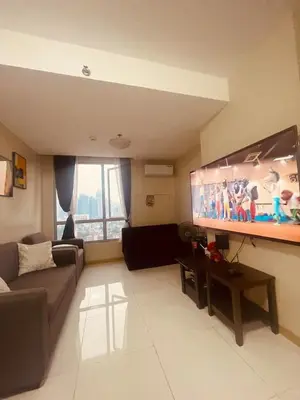 a living room with a couch and a flat screen tv at Cozy Studio Unit located at serene area in Manila