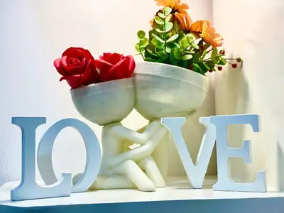 a white vase with flowers on top of the word love at CityHomeStay in Manila