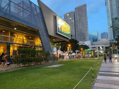 a building in a city with people walking on the grass at CityHomeStay in Manila