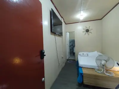 a small room with a bed and a fan at TerisitaPlace - BamboRoom in Taytay