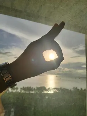 a hand making a peace sign in front of the sun at Chic Haven in Manila