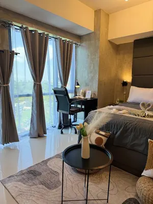 a bedroom with a bed and a desk and a table at Industrial Chic Studio in McKinley Hill Walk to Venice Mall in Manila