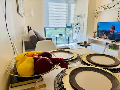 a bowl of fruit on a table in a living room at Cozy Viceroy 1BR, Walk to Venice Mall in Manila