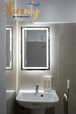 a bathroom with a white sink and a mirror at Shorenity MOA Staycation in Manila