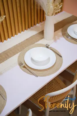 a table with white plates and a vase on it at Shorenity MOA Staycation in Manila