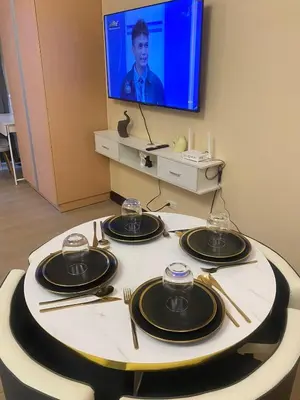 a table with plates and utensils and a television at The Serene Casa - EMANUELE TOWER in Manila