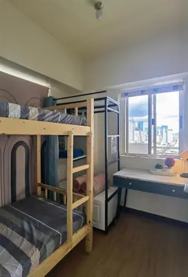 a dorm room with bunk beds and a window at Brixton Place in Manila