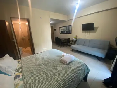 a living room with a bed and a couch at two palm tree villas condotel by kath in Manila