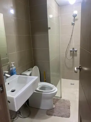 a bathroom with a toilet and a sink and a shower at two palm tree villas condotel by kath in Manila
