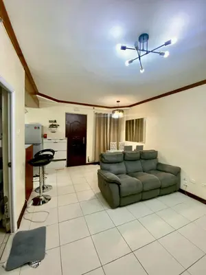 a living room with a couch and a ceiling fan at Dym cozy condo pad in Manila