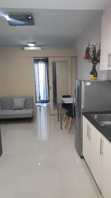 a kitchen and living room with a refrigerator and a couch at Suite Escapade in Manila