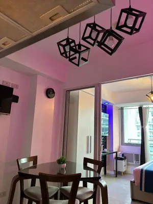 a dining room with pink walls and a table and chairs at Azure Urban Resort Residences by Staycationary 17th floor Miami in Manila