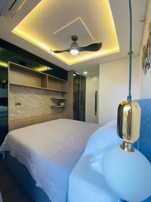 a bedroom with a white bed with a ceiling fan at Stylish & Spacious Place Near BGC Fast Wi-Fi in Manila