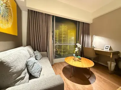 a living room with a couch and a table at MADR Excellence at Novotel Manila Hotel Residence Acqua in Manila