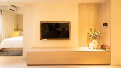 a bedroom with a tv on a wall at Cozy Flat at Makati s Coolest St in Manila