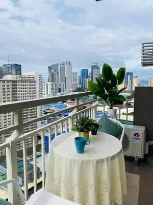 a table on a balcony with a view of a city at timoncondotel city view in Manila
