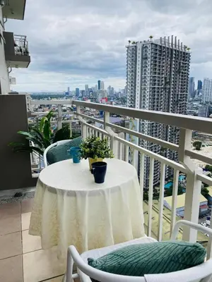 a table on a balcony with a view of a city at timoncondotel city view in Manila