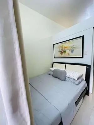 a bedroom with a bed with a picture on the wall at SMDC Shore Residences in Manila