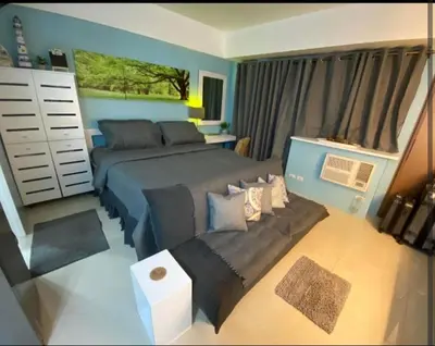 a bedroom with a bed and a couch at One Palm Tree Villas Near NAIA 3 in Manila