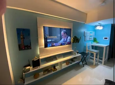 a living room with a flat screen tv on a wall at One Palm Tree Villas Near NAIA 3 in Manila