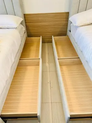 two beds in a room with wooden floors at Bella Notte Staycation - SMDC Shore 2 MOA Complex in Manila
