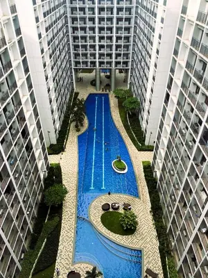 a swimming pool in the middle of two tall buildings at Bella Notte Staycation - SMDC Shore 2 MOA Complex in Manila