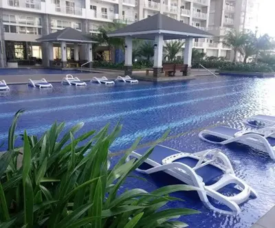 a pool with lounge chairs and flip flops on it at CASA ROYALE Affordable Condo Near BGC Ortigas Center CBD in Manila